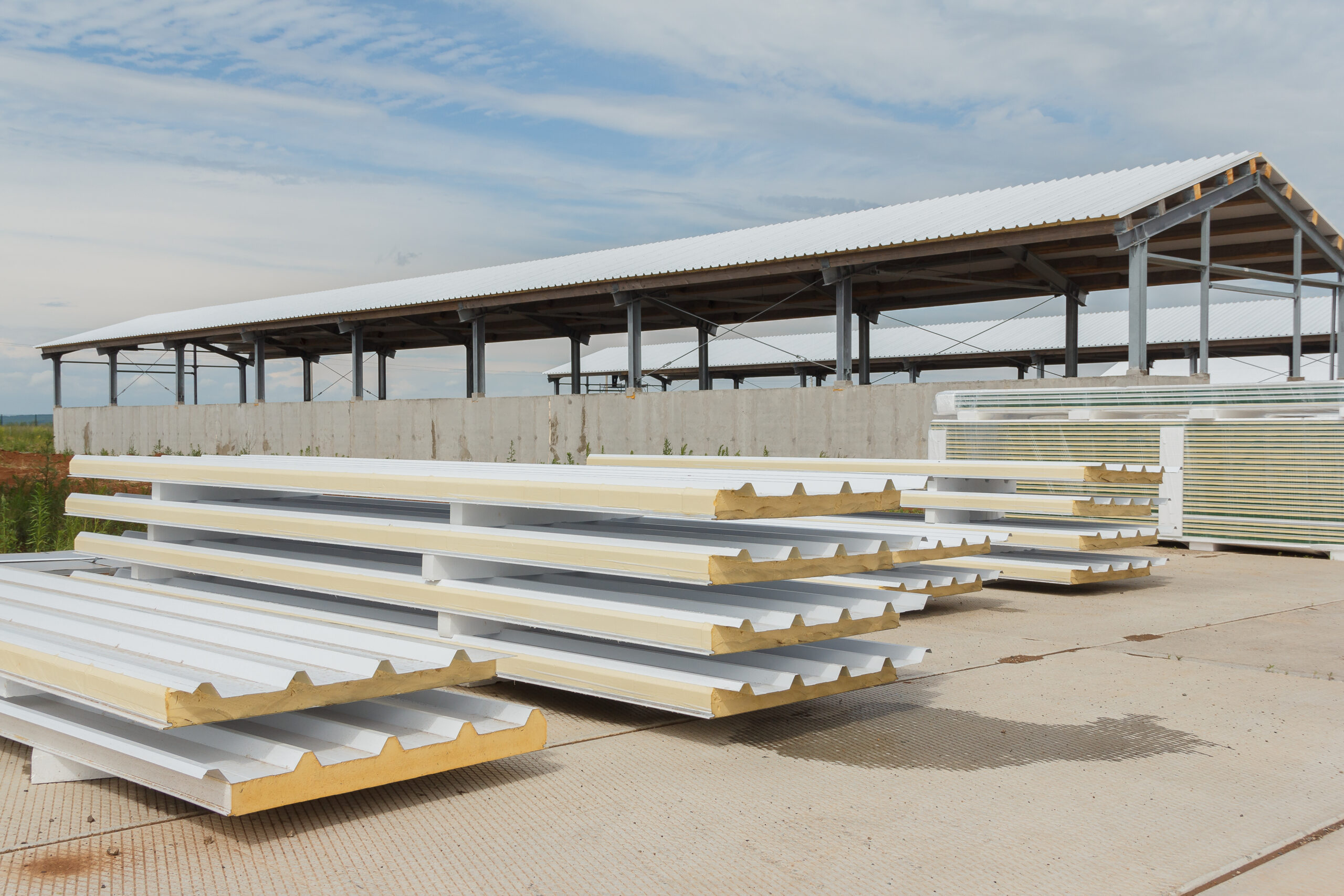 Metal frame of the building with a sandwich panel of insulation on the wall. Construction of a new industrial building. Modern Insulation of the walls of the building panels of insulation.