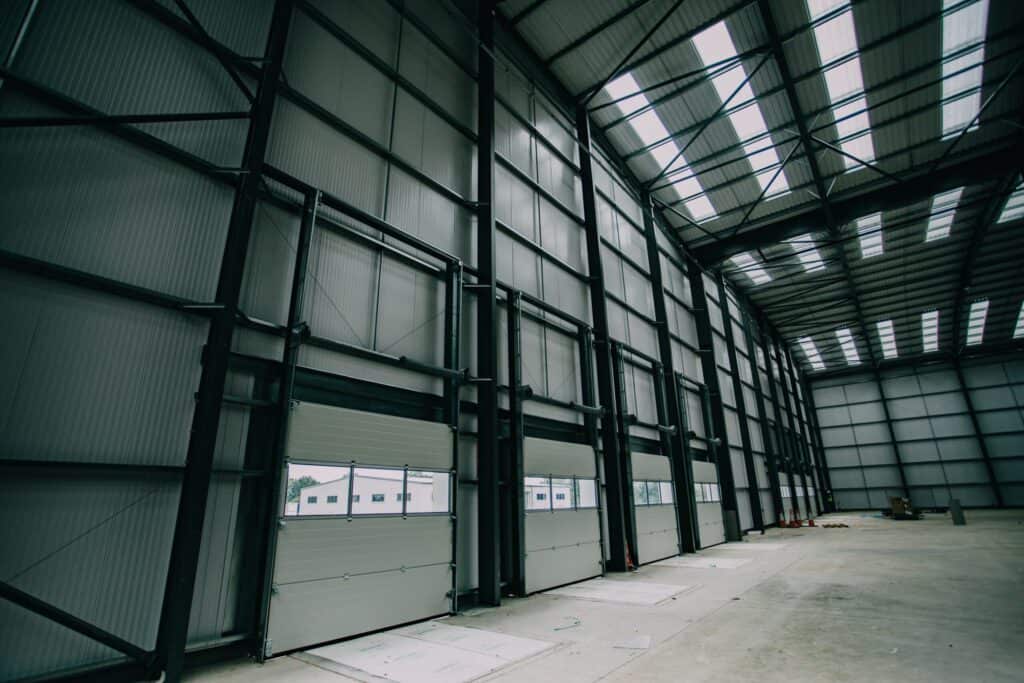 Loading bay doors along the wall of a large steel frame warehouse